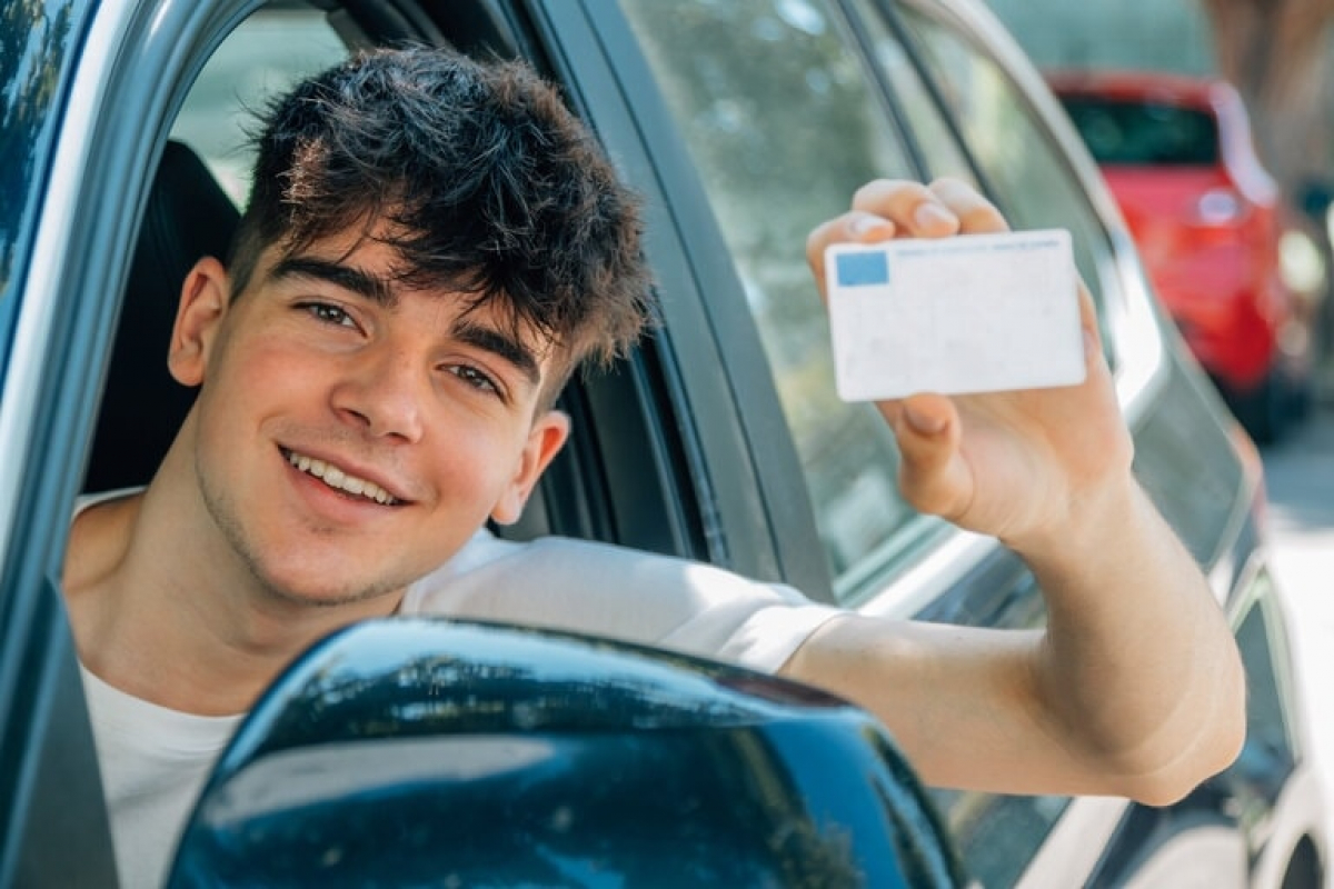 Jeune homme heureux d’avoir obtenu et de montrer son permis de conduire