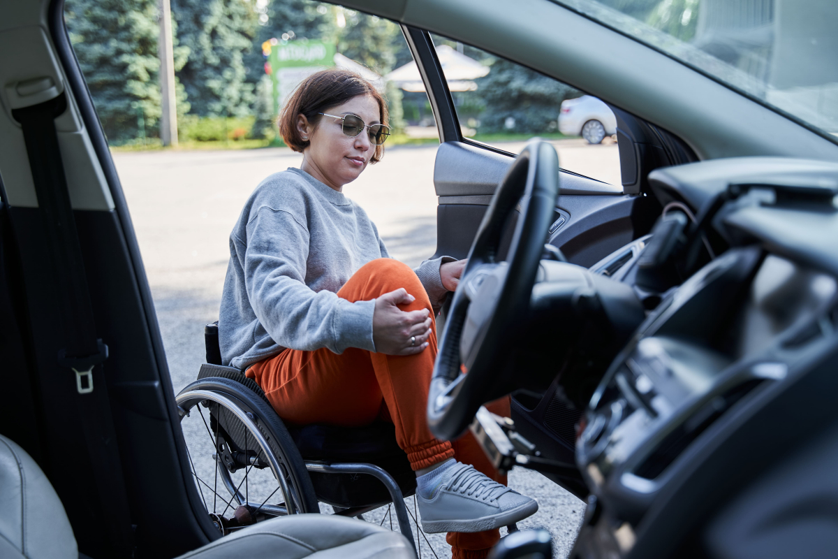 Jeune conductrice en fauteuil roulant montant dans sa voiture