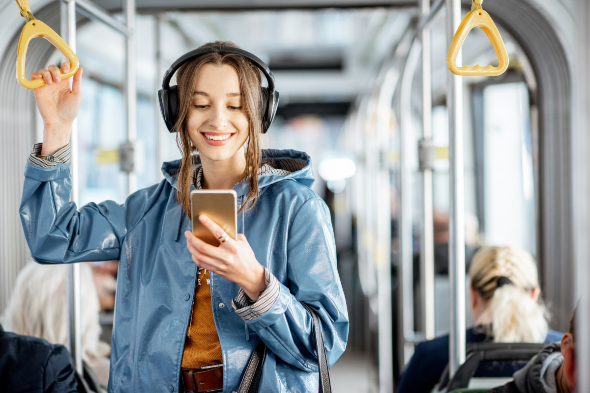 Jeune fille qui révise son code de la route sur son smartphone dans les transports en commun