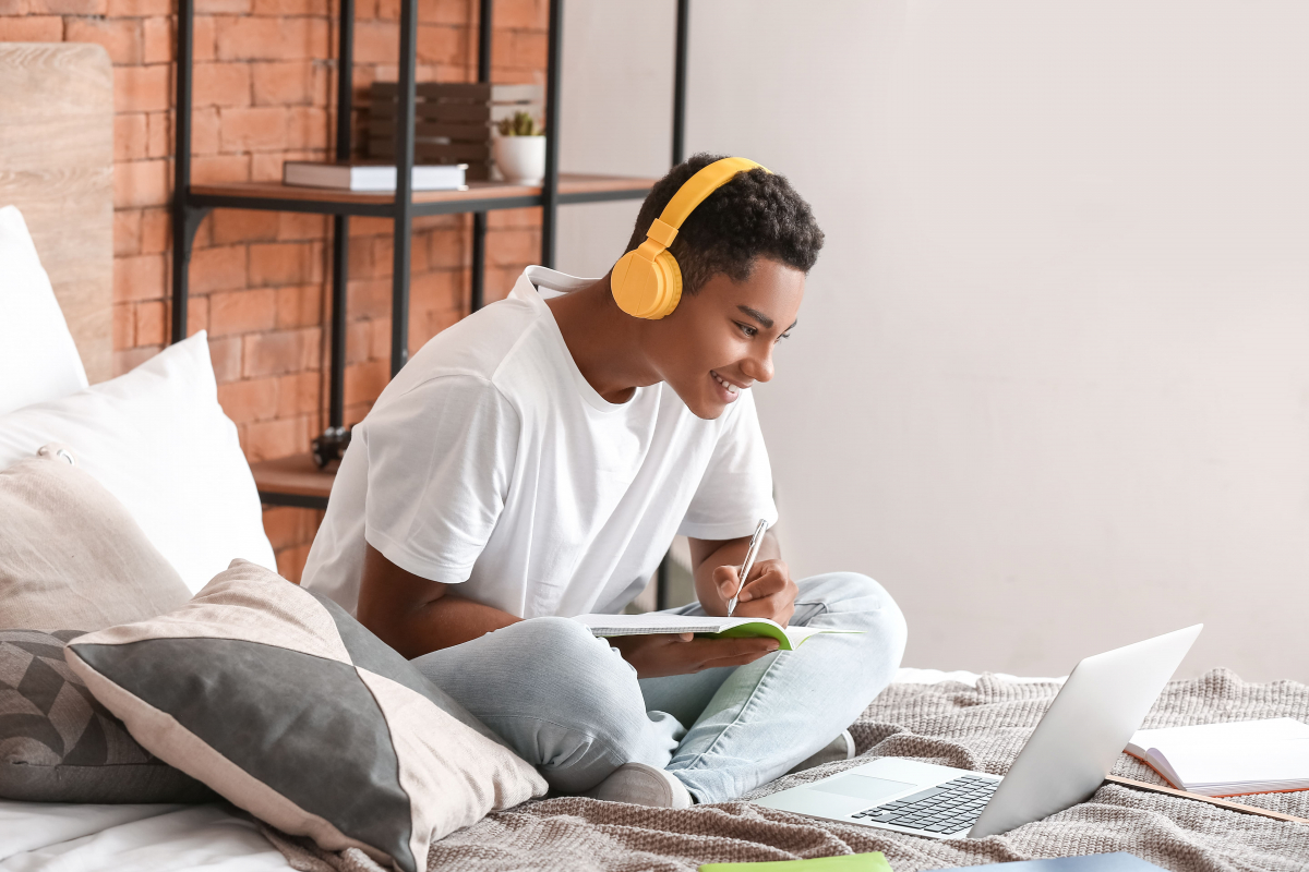 Adolescent qui révise le code de la route avec son livre de code et des cours en ligne